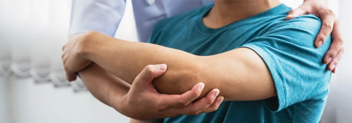 Healthcare professional examining a patient's elbow