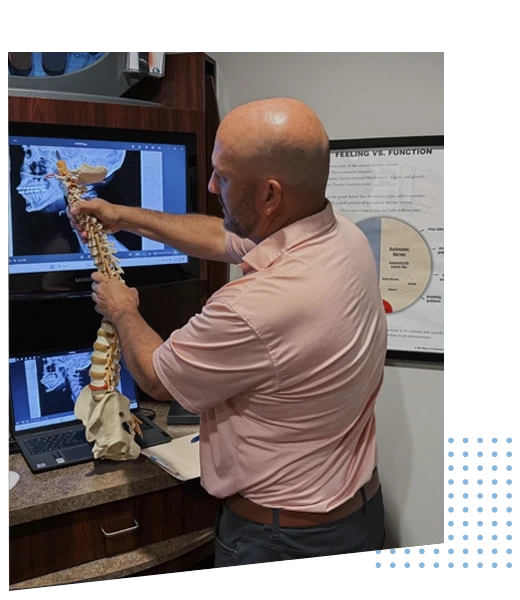 Quinn Uzelman Holding a Model Spine With Computer