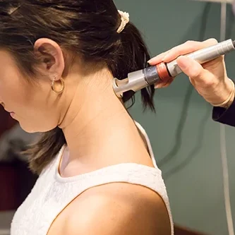 Laser Technician Performing Treatment on Patient Neck