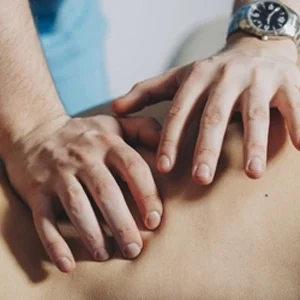 close-up of a person giving a back massage to a patient.